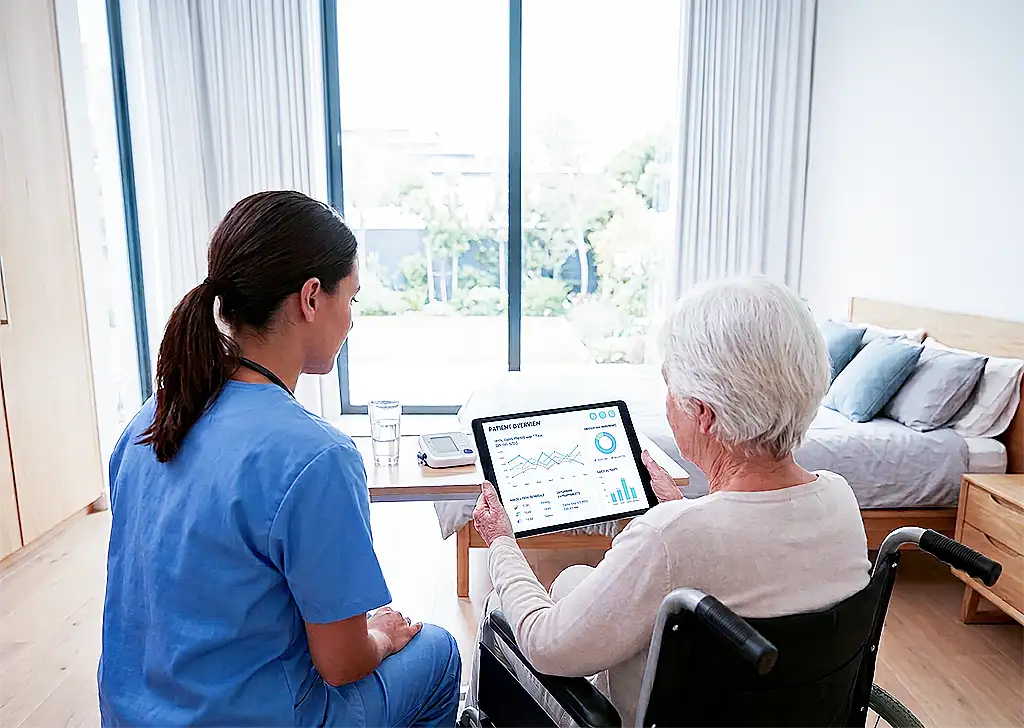 Elderly woman in wheelchair using tablet with caregiver beside her in a bright modern room.